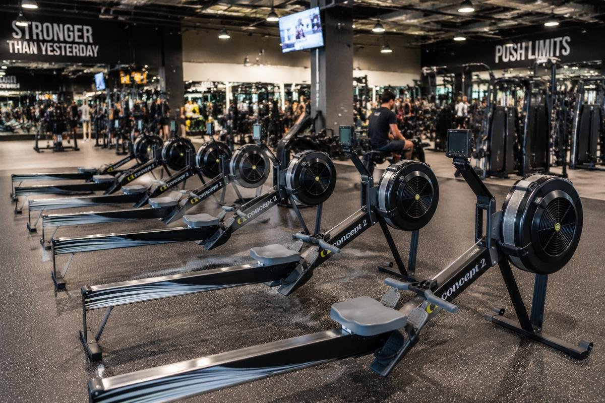 Rowing machines deployed in a high-traffic gym setting A commercial gym floor with multiple rowing machines arranged for member use